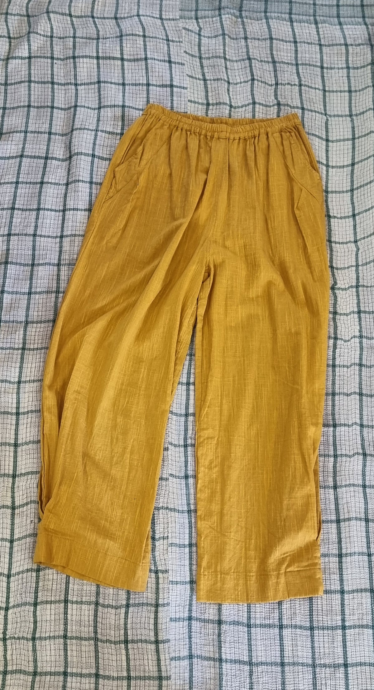 "Open Hearts Mend artisanal cotton/linen trousers with an elastic waistband, pockets, cropped silhouette, and hand-dyed finish for unique style and sustainability."