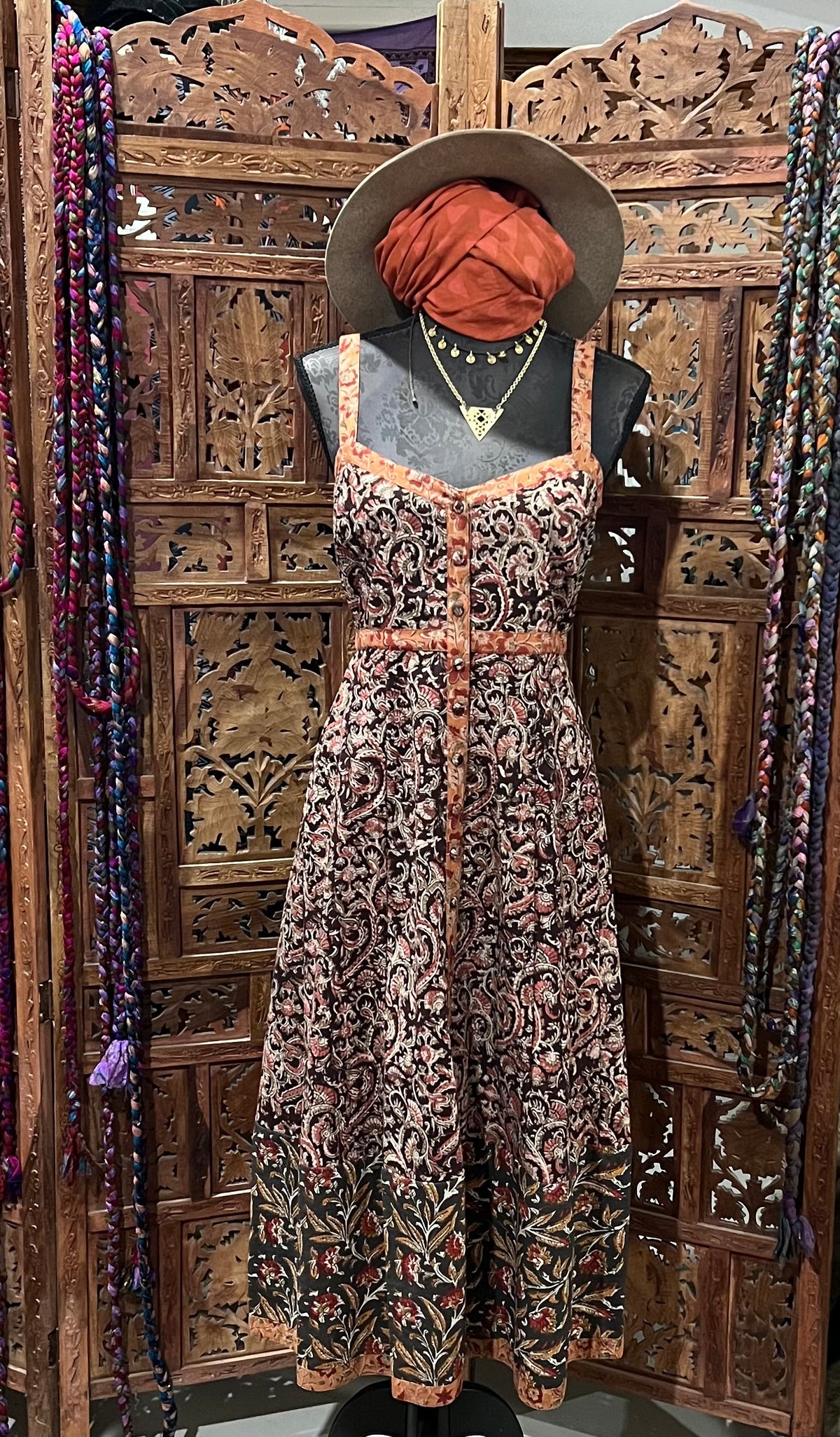 Lightweight cotton summer dress with block print, covered buttons, and breezy silhouette. Available in sizes SM (6-8) and ML (10-12). Paired with a fashionable bomber jacket and soft scarf for a chic, versatile summer look.