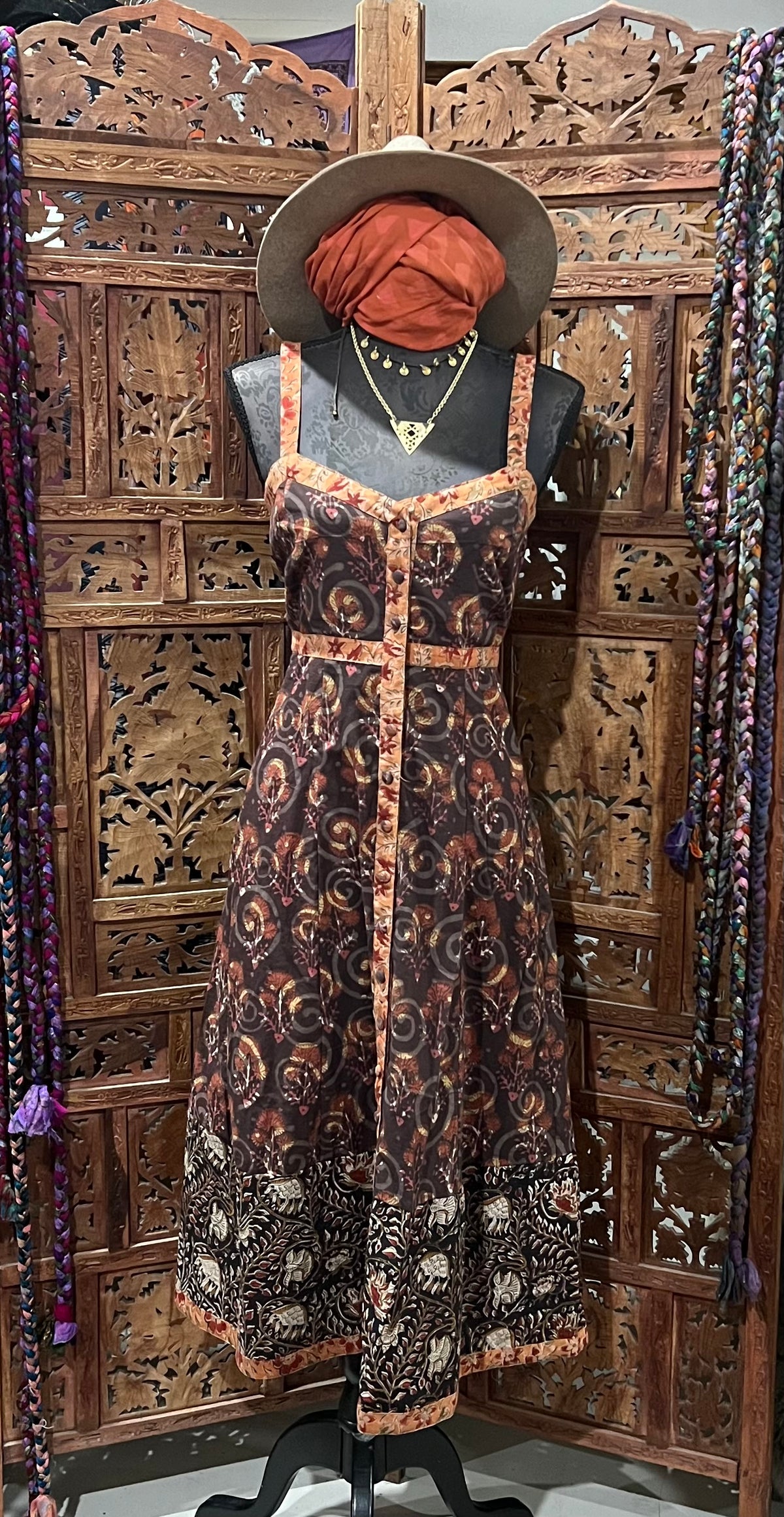 Lightweight cotton summer dress with block print, covered buttons, and breezy silhouette. Available in sizes SM (6-8) and ML (10-12). Paired with a fashionable bomber jacket and soft scarf for a chic, versatile summer look.