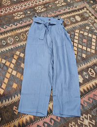 "High-waisted, super baggy cropped pants in a hand-dyed cotton linen blend with front pleats, pockets, zip closure, and a waist-accentuating belt."