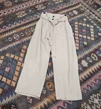 "High-waisted, super baggy cropped pants in a hand-dyed cotton linen blend with front pleats, pockets, zip closure, and a waist-accentuating belt."