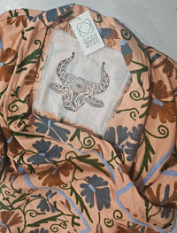 Hand-embroidered Suzani Taurus Flower Coat by Open Hearts Mend. Unique floral designs, outsize fit for sizes 10-20, one-of-a-kind craftsmanship. Perfect for adding artisanal elegance to your wardrobe.